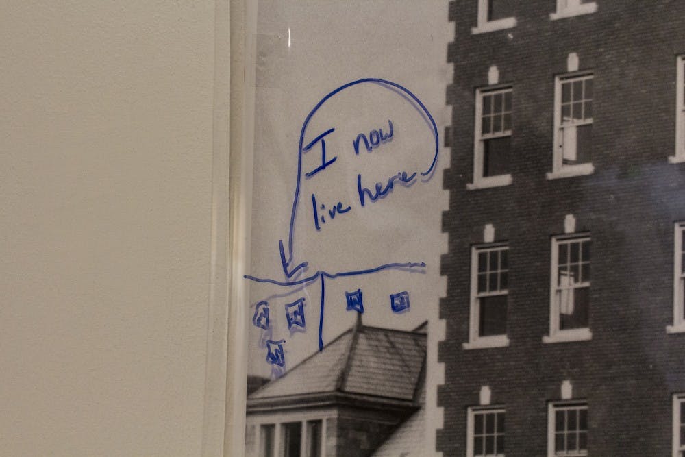 <p>A note left by a museum attendee is on display over one of the historic photographs as part of the “Memories Shared: Photographs of Historic Bloomington” exhibit Tuesday at the Mathers Museum of World Cultures. A sheet of plastic was placed over each of the photographs so museum attendees could draw pictures and leave notes. The exhibit runs until July 27.&nbsp;</p>