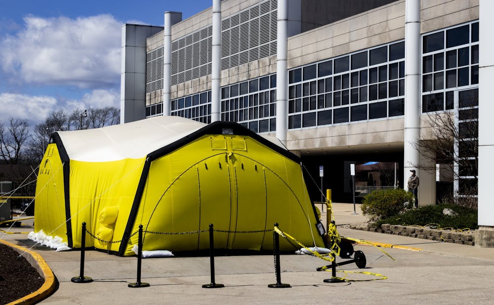 <p>A yellow tent stands outside March 29 at IU Health Bloomington Hospital. IU Health officials advise patients experiencing COVID-19 symptoms to be tested in the tent. Gov. Eric Holcomb signed an executive order Monday that grants some medical professionals without active licenses permission to practice, according to a release. </p>