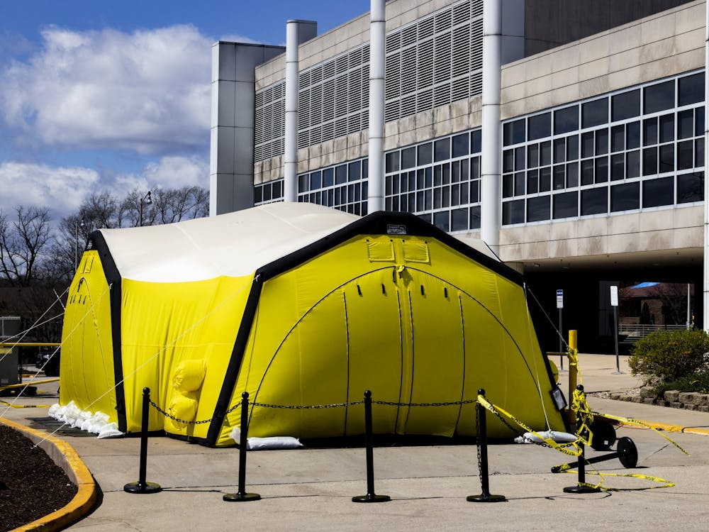 A yellow tent stands outside March 29 at IU Health Bloomington Hospital. IU Health officials advise patients experiencing COVID-19 symptoms to be tested in the tent. Gov. Eric Holcomb signed an executive order Monday that grants some medical professionals without active licenses permission to practice, according to a release. 