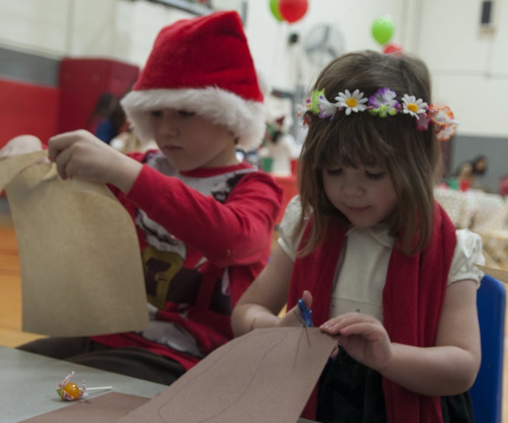Seven-year-old Jackson and 3-year-old Harper Jent cut antlers out for their reindeers during Breakfast with Santa on Saturday, Dec. 14, 2013 at the YMCA.The YMCA’s Center for Children and Families (YCCF) was started in 2013 as a licensed child care center to offer educational services and care to children 6 weeks to 5 years old.