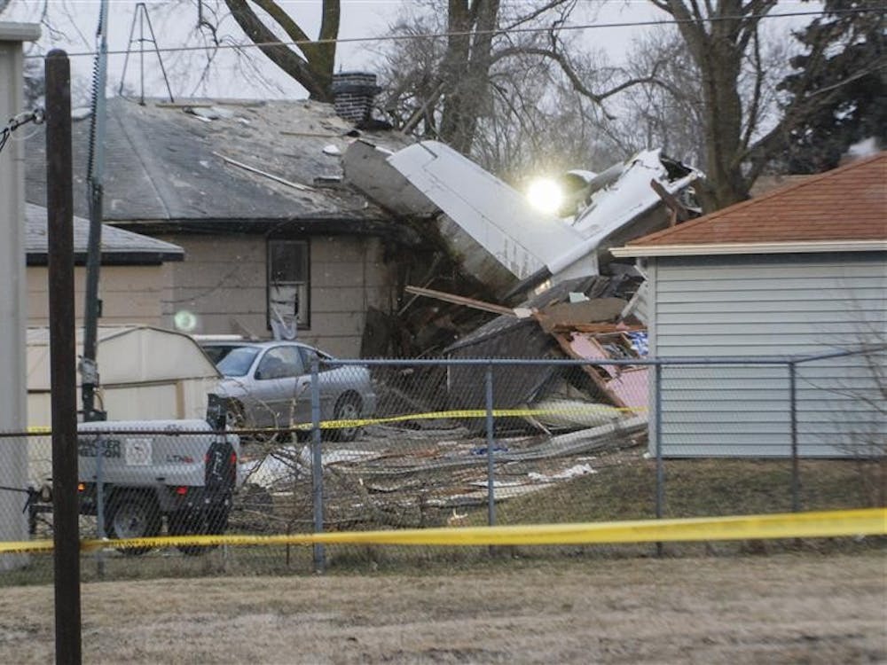 Emergency crews work to remove what remains of a private plane which crashed into the Kobalski house in South Bend, Indiana on St. Patricks day, killing two and injuring three. The accident happened only minutes from the South Bend Regional Airport.