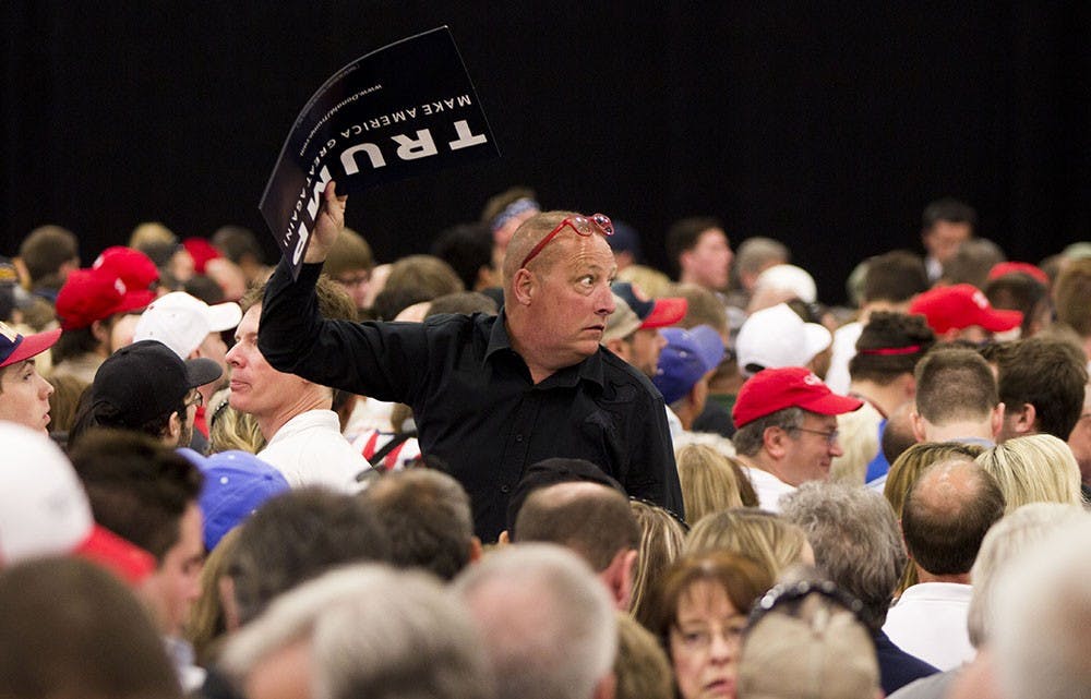 A Trump supporter glances back to protestors being removed from a rally Wednesday at the Elements Financial Blue Ribbon Pavilion.  Many demonstrators were removed. 