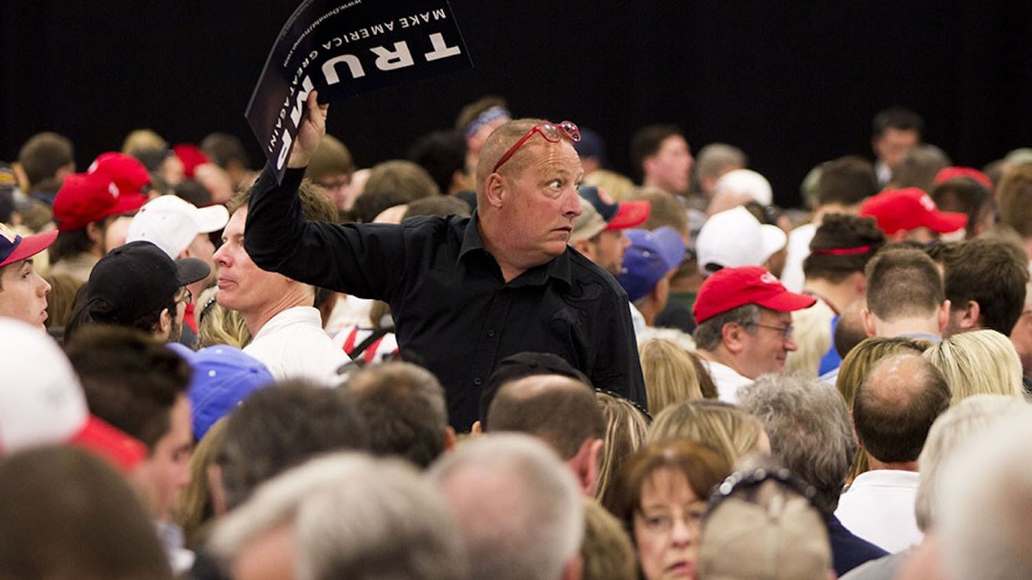 A Trump supporter glances back to protestors being removed from a rally Wednesday at the Elements Financial Blue Ribbon Pavilion. Many demonstrators were removed.