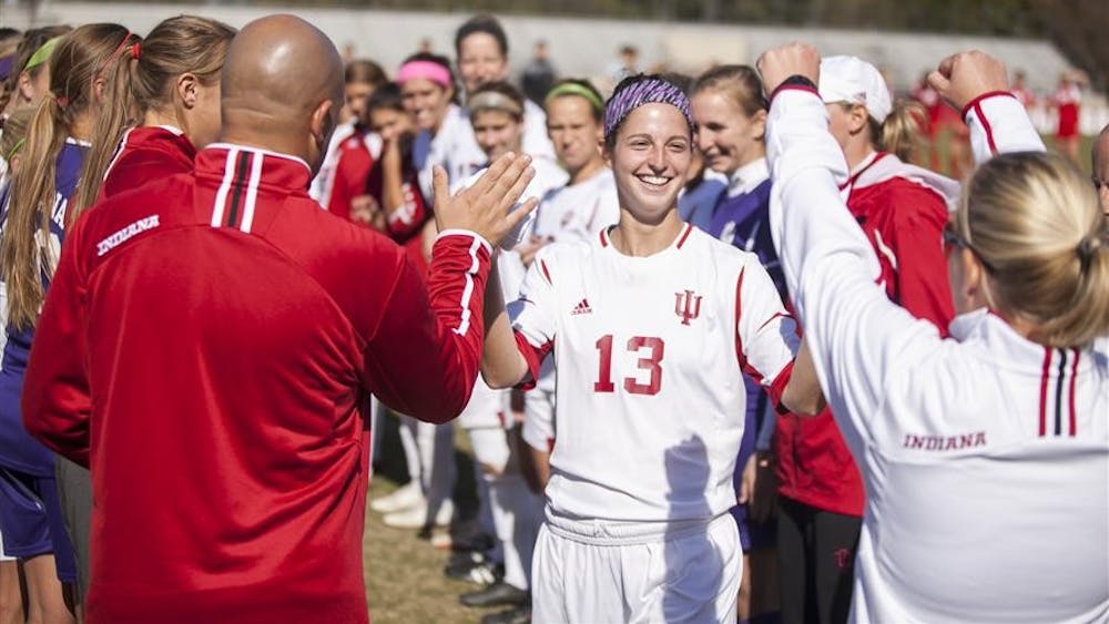 Junior midfielder Bekah White exchanges high fives with teammates and coaches as she runs through the player tunnel on Oct. 27 before the match against Wisconsin at Bill Armstrong Stadium. The Hoosiers won 1-0, clinching a berth in the Big Ten Tournament. 