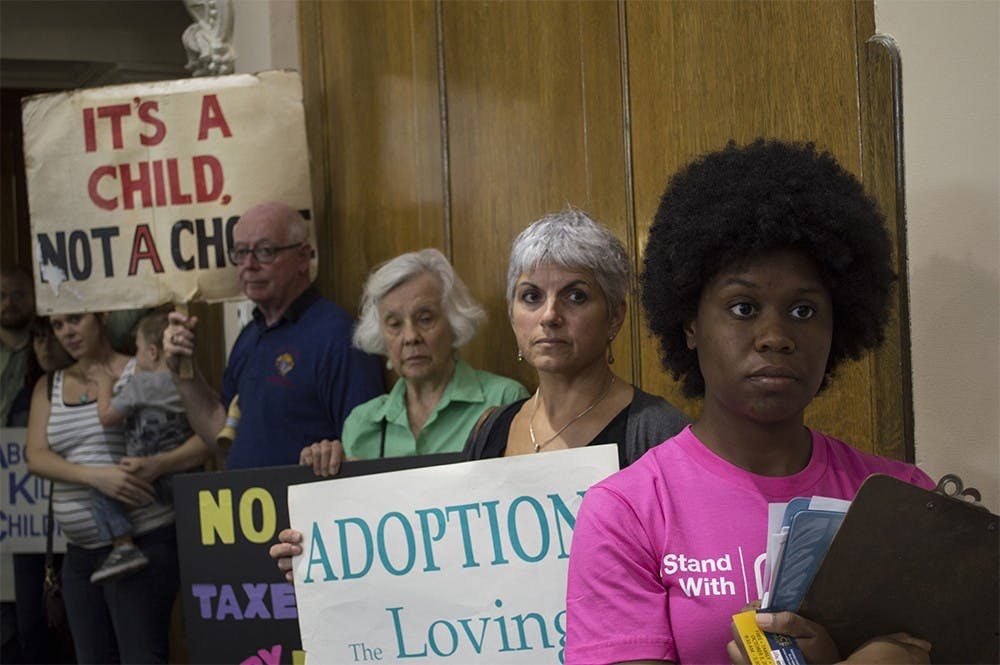 Wanda Savala, Community Engagement Coordinator with Planned Parenthood in Indiana and Kentucky, stands in front of protesters on Tuesday in a county council meeting. The council voted 6-1 to use service grant money to help fund Planned Parenthood.