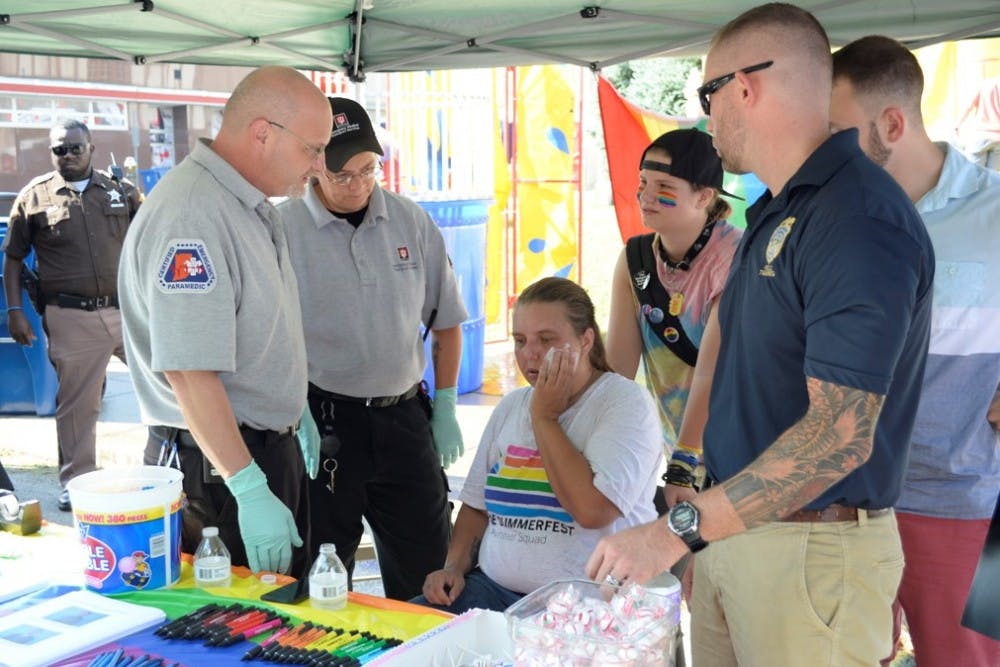 BPD Sgt. David Alley looks after a passerby after she suffered from heat stroke Saturday afternoon at Summerfest. Other officers went and brought the EMTs to take her out of the heat.
