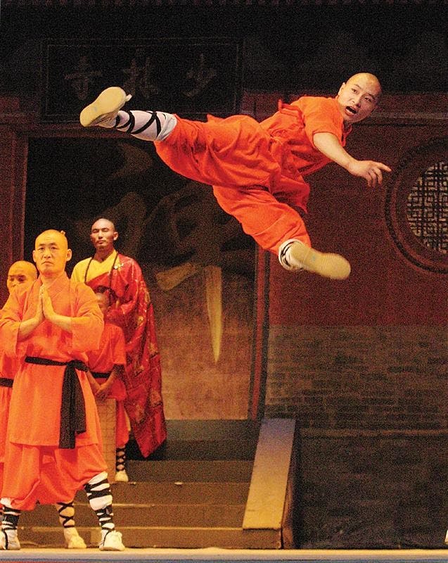 A member of the Shaolin Warriors performs a flying kick in the IU Auditorium. 