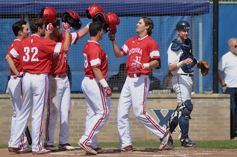 Senior Brian Wilhite is congratulated by a crowd at home plate after his grand slam in Indiana's game against Xavier Wednesday at Hayden Field in Cincinnatti, Ohio. The Hoosiers shutout Xavier, winning 8-0.