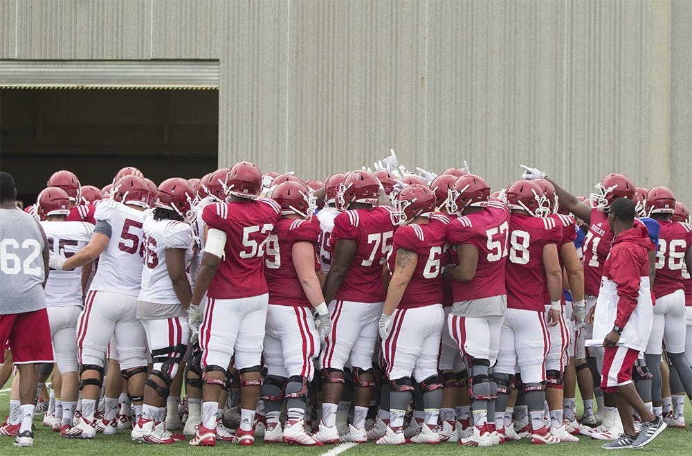 Members of the football team huddle up during a morning practice at Mellencamp Pavillion on Wednesday. The team's first game will be on September 5 against Indiana State at Memorial Stadium.