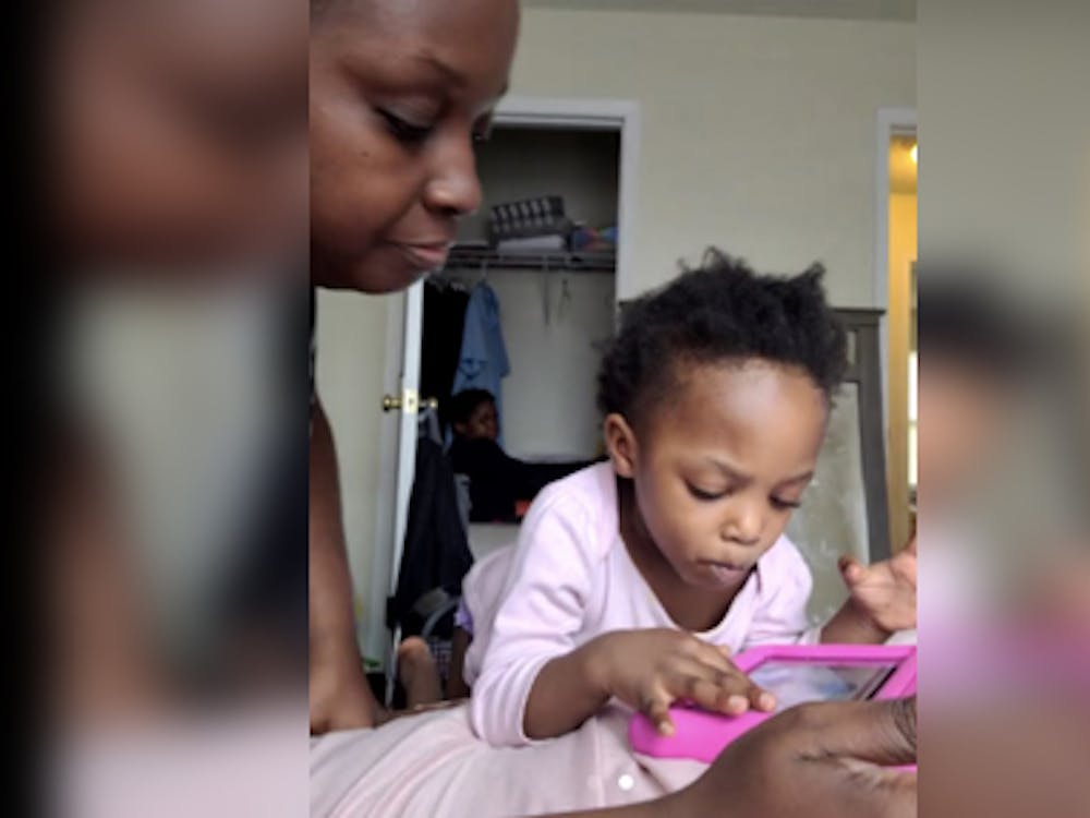 伊莉莎·凯里和她2岁的女儿马卡拉·杰克逊一起玩耍。两人坐在凯莉的床上，她的儿子CJ Mason坐在后面的壁橱里。
