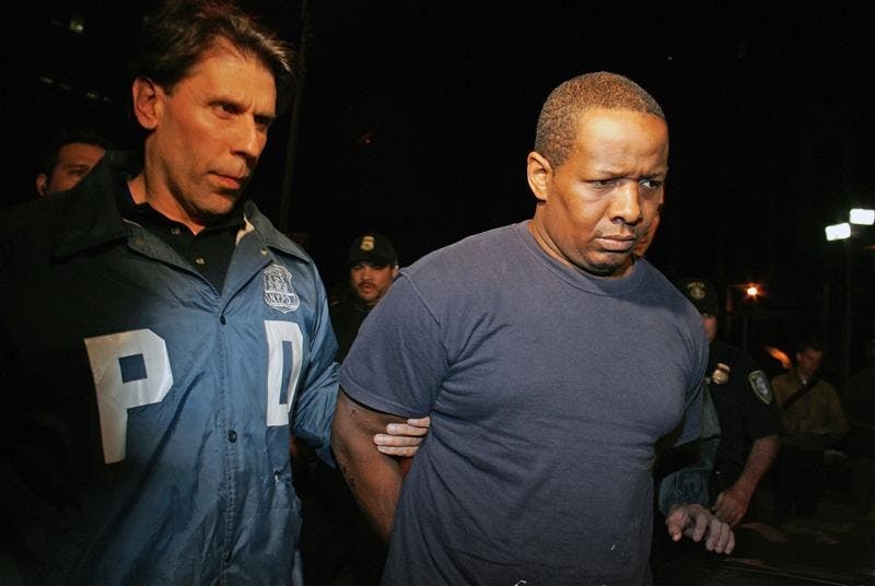 James Cromitie, right, is led by police officers from a federal building on Thursday in New York after being arrested on charges related to a bombing plot in the Bronx. The FBI arrested four men Wednesday in what authorities called a plot to detonate a bomb outside a Jewish temple and to shoot military planes with guided missiles.