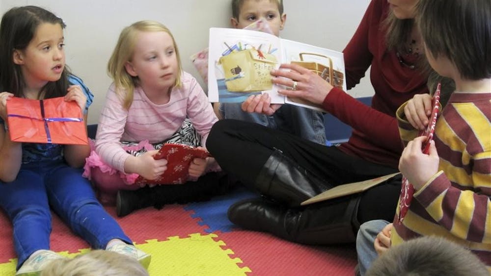 Sarah Murray reads "Splat the Cat" to her kindergarten class on Thursday at Childs Elementary School. The students were participating in International Book Giving Day, which aims to increase children's access to, and enthusiasm for, reading.