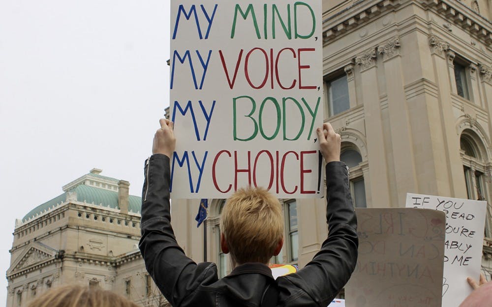 Elizabeth Danner Creakbaum holds a sign during the Women's March in Indianapolis on Saturday.