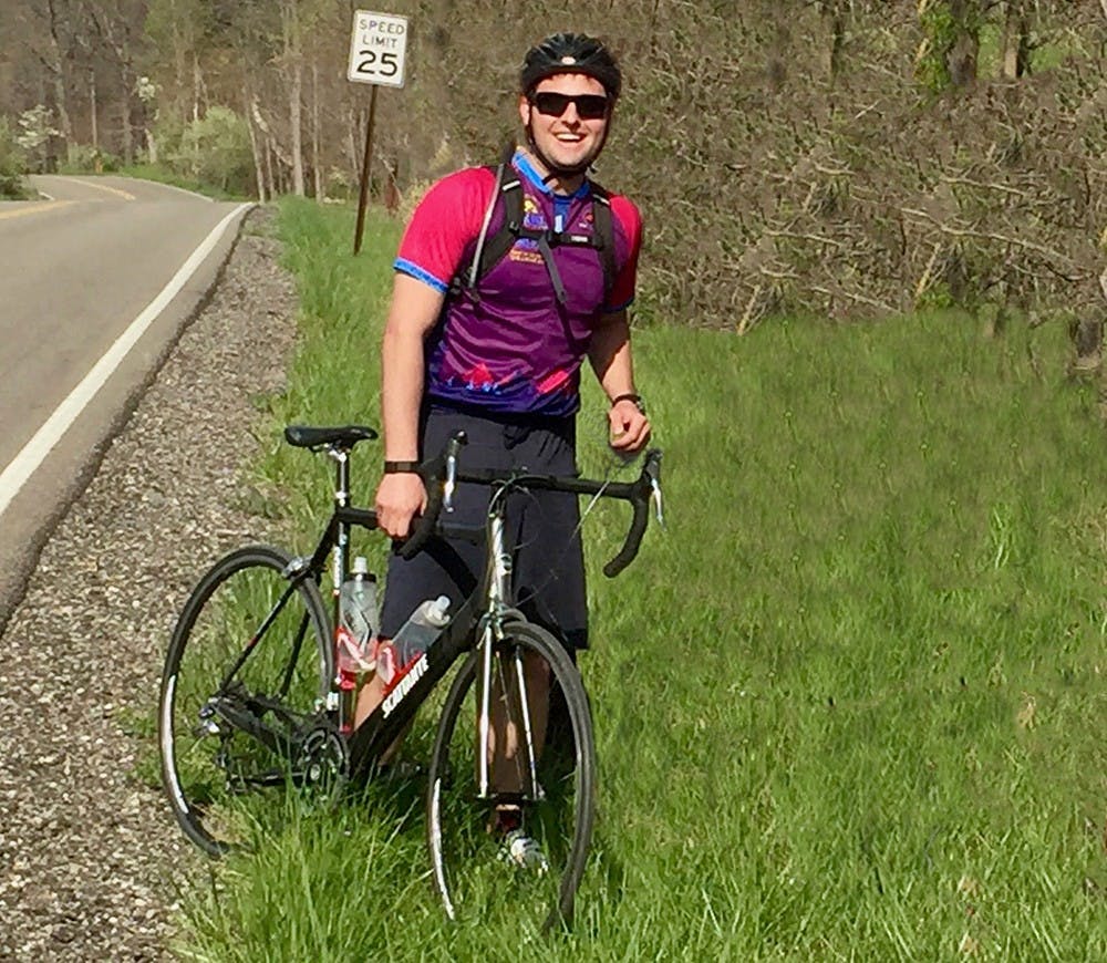 Assistant professor Alex Hollingsworth poses with his bike during a cross-country tour he joined with researchers from the University of Arizona. The team interviewed people living in rural America about how they viewed the Affordable Care Act (Courtesy Photo). 