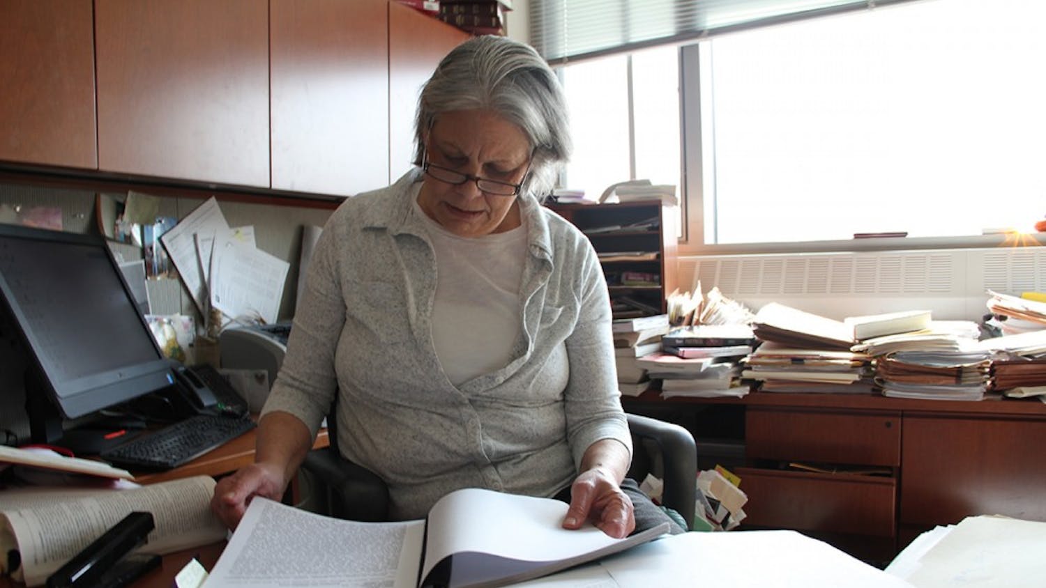 Fran Watson, an IU law professor, looks over the original police report on the "bump, rape and rob." The victim told police she was assaulted by young, black men. Darryl Pinkins was 38 at the time.