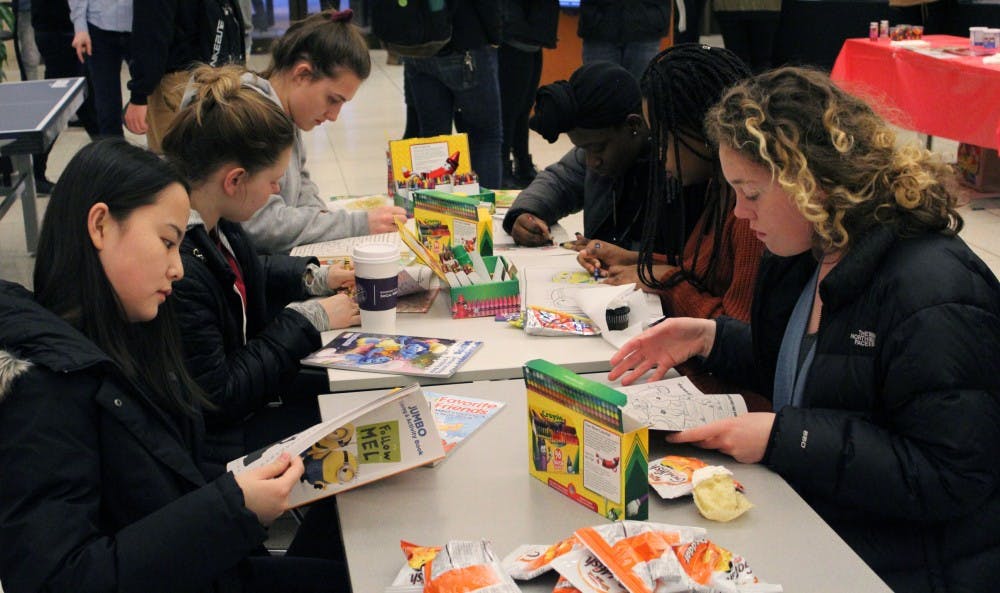 <p>Sarah Nagy from the Office of First Year Experiences has a booth providing students with the opportunity to color with crayons and eat childhood snacks like Fruit Roll-Ups, Goldfish crackers and Gushers.&nbsp;</p>
