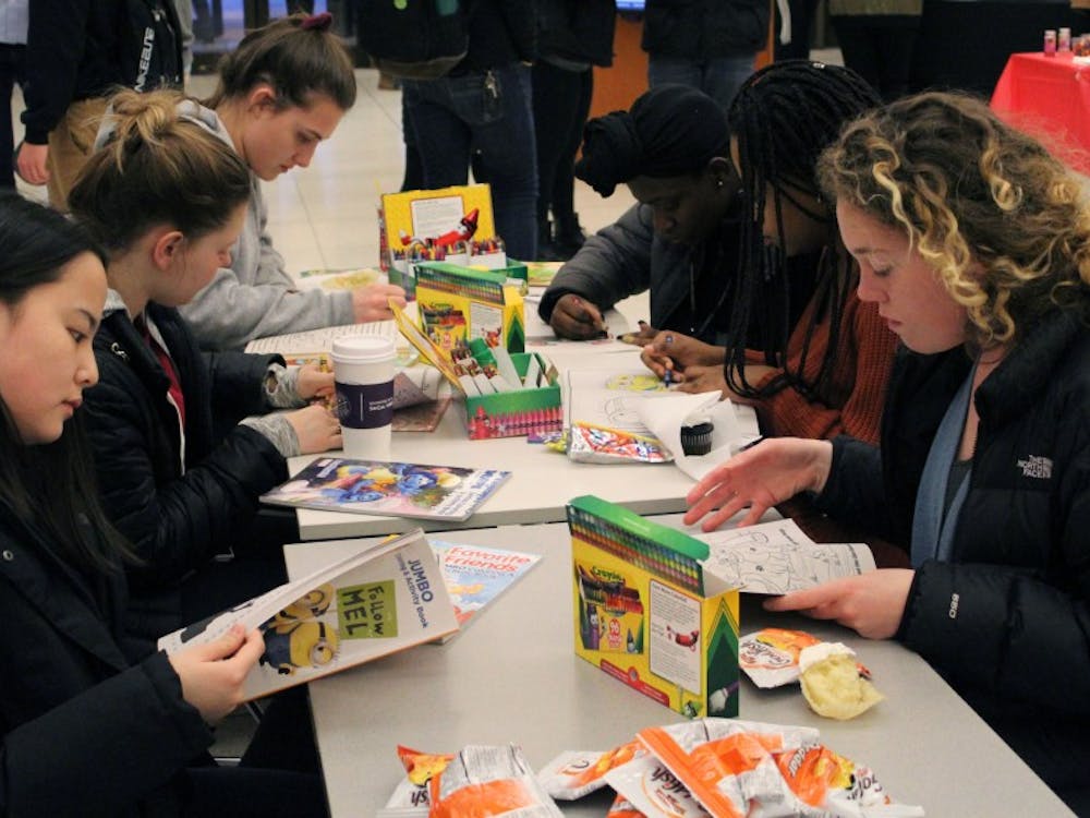 Sarah Nagy from the Office of First Year Experiences has a booth providing students with the opportunity to color with crayons and eat childhood snacks like Fruit Roll-Ups, Goldfish crackers and Gushers.&nbsp;