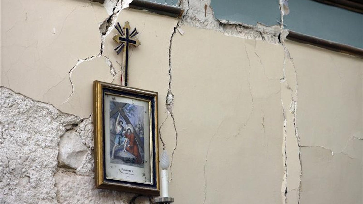 Cracks are seen in the wall of a house Monday in the village of Castelnuovo, central Italy, following a strong earthquake. A powerful earthquake in mountainous central Italy knocked down whole blocks of buildings early Monday as residents slept, killing more than 90 people in the country's deadliest quake in nearly three decades, officials said. Tens of thousands were homeless and 1,500 were injured.