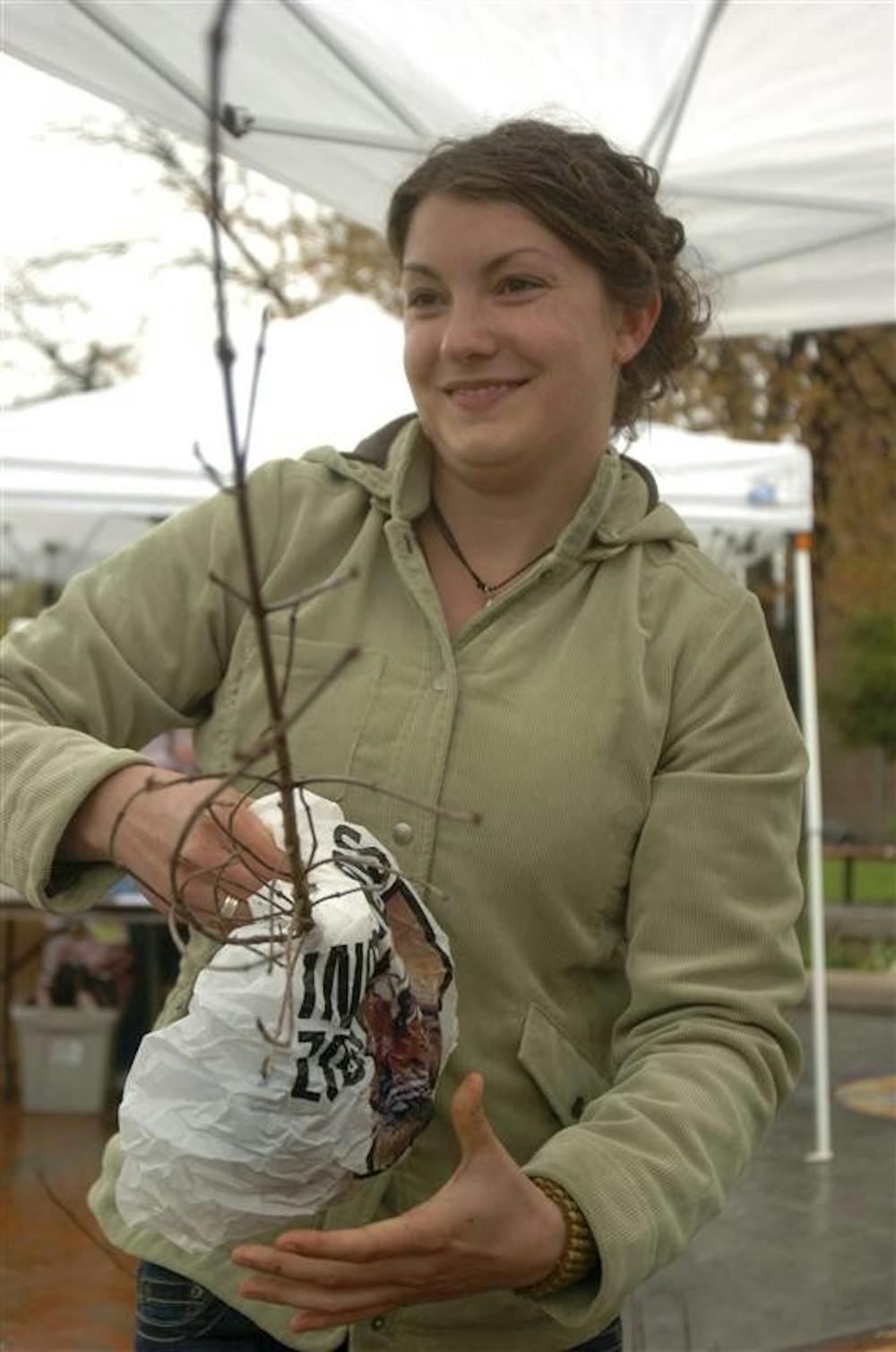 SPEA graduate student Carmen Blubaugh hands out a free tree in celebration of Earth Day on Tuesday afternoon in People's Park. The Environmental Management Association was handing out free White Oak, Black Gum and Dogwood trees because of their ability to clean air pollutants and improve neighborhood appeal among other reasons.