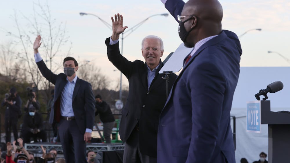 President-elect Joe Biden, along with Senator-elects Jon Ossoff and Rev. Raphael Warnock, greet supporters on Jan. 4, 2021 during a campaign rally in the parking lot of Centerparc Stadium in Atlanta.