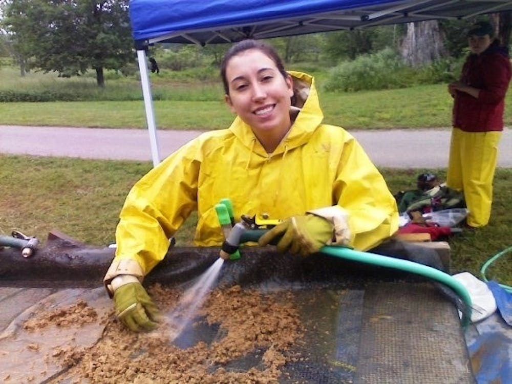 Megan Geurts water screens to find small remnants missed while digging.