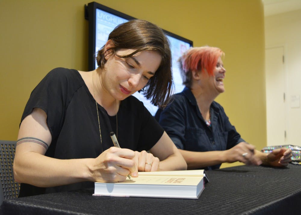 Journalistic cartoonist Sarah Glidden signs her book, "Rolling Blackouts" after the Refugees, Art and Journalism talk Monday night. She said she used universal symbols she saw abroad, such as a blue plastic chair, to show how Western culture connects to the Middle East and refugee crisis.