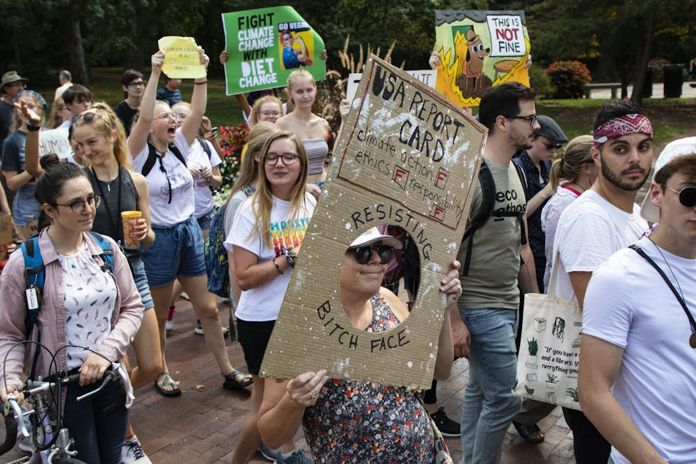 <p>Protestors walk with their signs during the Bloomington Climate Strike rally Sept. 20 in front of Franklin Hall. Mayor John Hamilton proposed an income tax at the beginning of January to help fight climate change.</p>