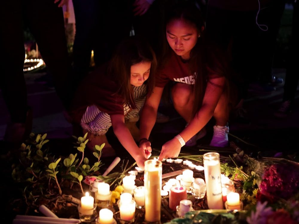 People light candles for a makeshift memorial Feb. 14 after an interfaith ceremony at Pine Trails Park in Parkland, Florida, to remember the 17 people killed last year at Marjory Stoneman Douglas High School.