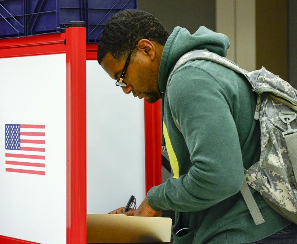 <p>Chris Wesley fills out a ballot during 2016 the presidential primary election in May at Cedar Hall.&nbsp;</p>