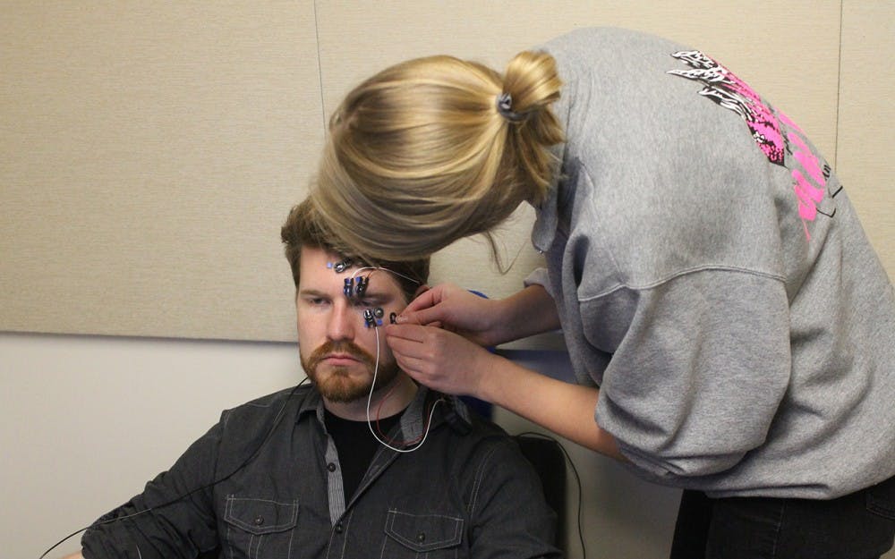 Claire Dudek attaches sensors to a test subject during a study in the Institute for Communication Research located inside Franklin Hall. This research is studying the effects of music on decision making.