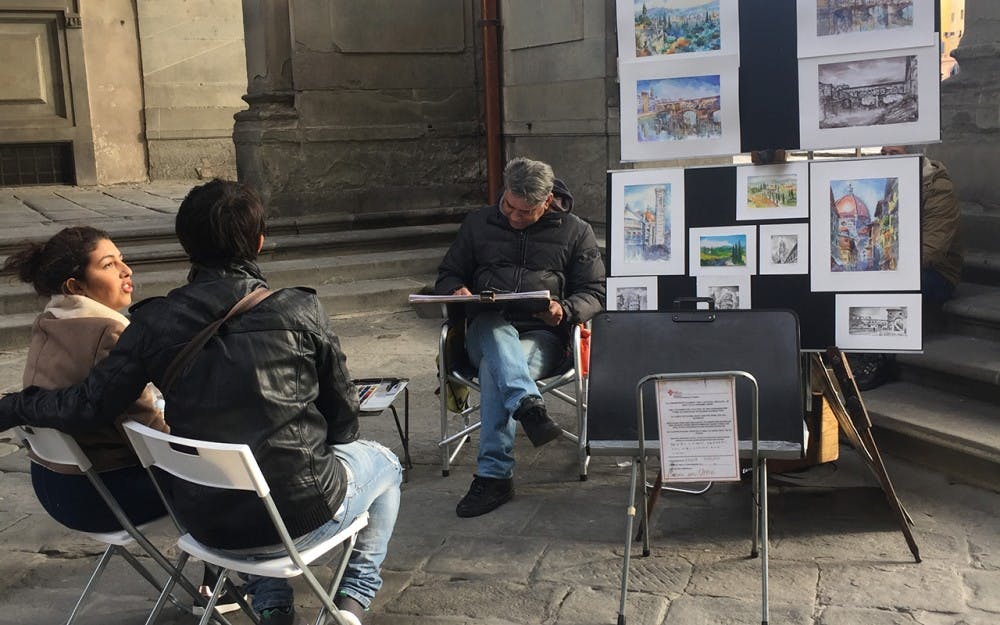 An artists practices his craft on the side streets of Florence, Italy. His work can be surprising to the viewers because of his skill.  
