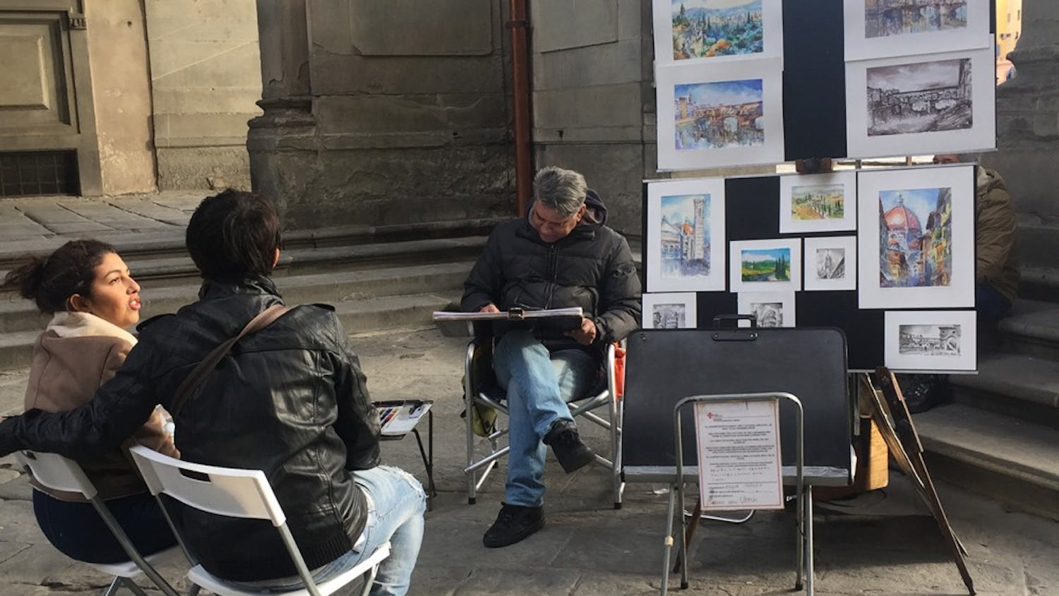 An artists practices his craft on the side streets of Florence, Italy. His work can be surprising to the viewers because of his skill.  