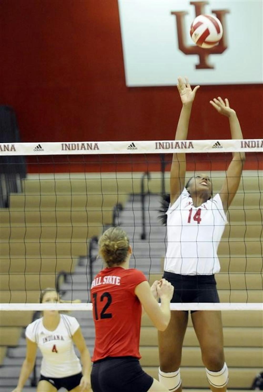 IU freshman Lexie Woodson, No. 14, sets the ball as Ball State's Jennifer Boyd, No. 12, watches from across the net during the TIS Bookstore Invitational on Friday, Sept. 19 at University Gym. IU swept Ball State 3-0.