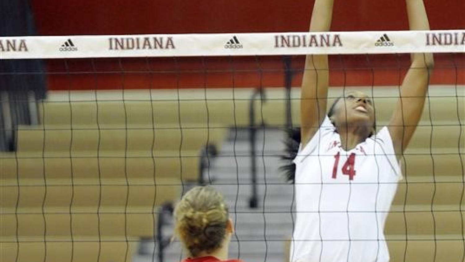 IU freshman Lexie Woodson, No. 14, sets the ball as Ball State's Jennifer Boyd, No. 12, watches from across the net during the TIS Bookstore Invitational on Friday, Sept. 19 at University Gym. IU swept Ball State 3-0.