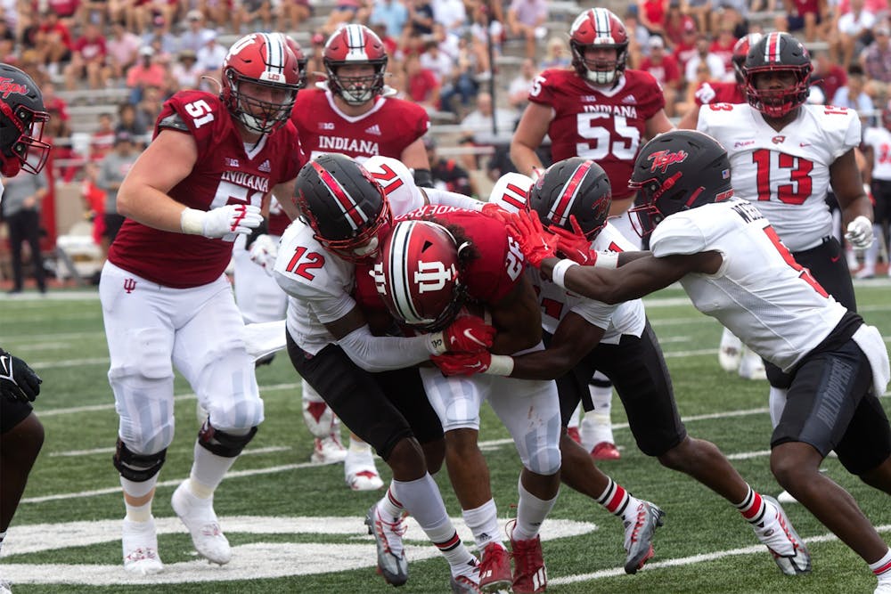 <p>Senior running back Josh Henderson fights to keep his grip on the ball while being tackled by Western Kentucky University players Sept. 17, 2022, at Memorial Stadium. Indiana defeated Western Kentucky 33-30.</p>