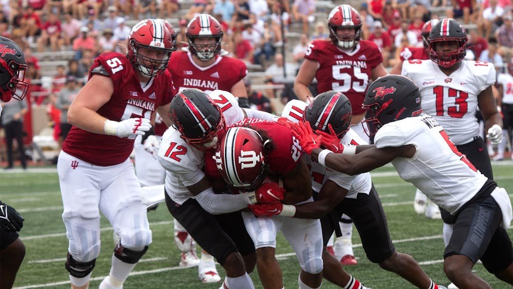 Senior running back Josh Henderson fights to keep his grip on the ball while being tackled by Western Kentucky University players Sept. 17, 2022, at Memorial Stadium. Indiana defeated Western Kentucky 33-30.