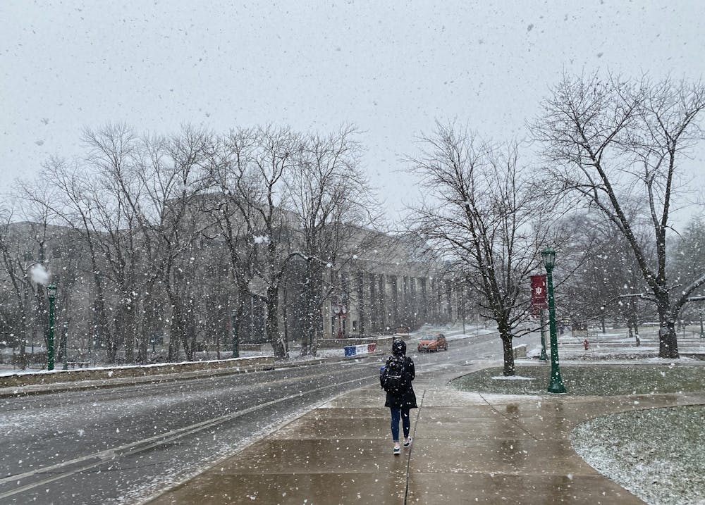 2月9日，一名印第安纳大学学生在约旦大道上走过雪。据美国国家气象局称，周二晚些时候，布卢明顿预计将迎来一英寸降雪。