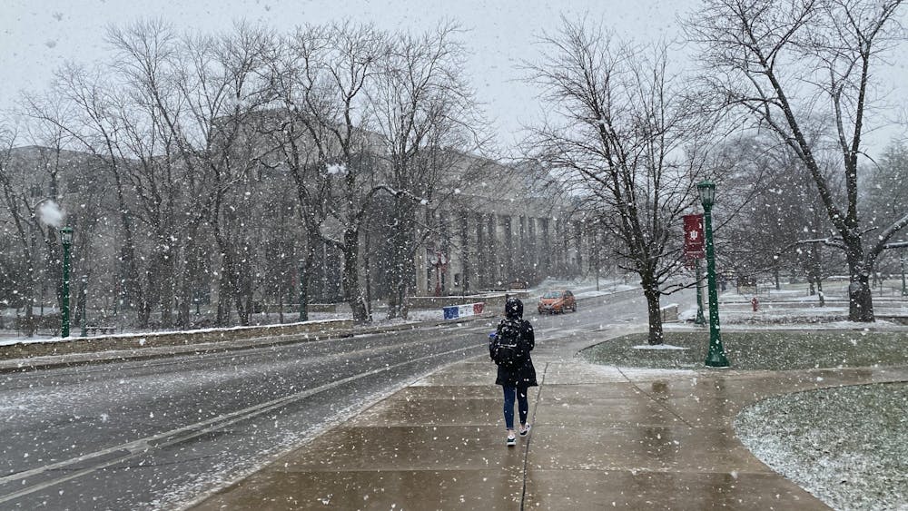 2月9日，一名印第安纳大学学生在约旦大道上走过雪。据美国国家气象局称，周二晚些时候，布卢明顿预计将迎来一英寸降雪。