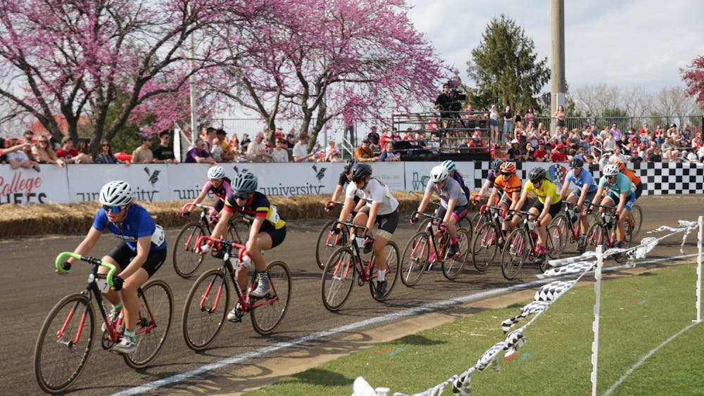 Bikers ride in the first lap of the Women&#x27;s Little 500 on April 22, 2022, at Bill Armstrong Stadium. The race starts with three pacing laps led by a car. 