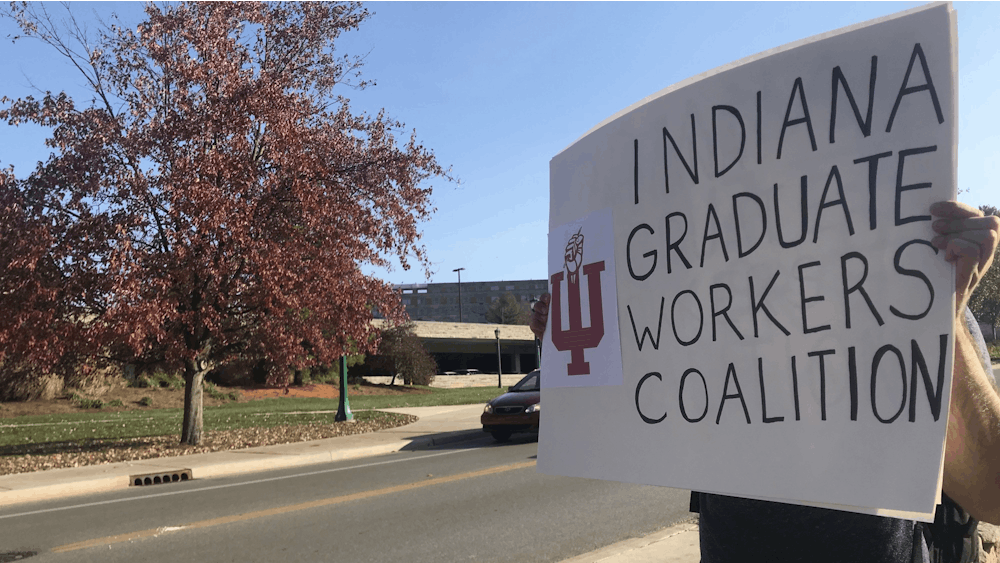 Members of the Indiana Graduate Workers Coalition protest Nov. 10 on Jordan Avenue. The members protested on behalf of Jacobs School of Music students and performers.