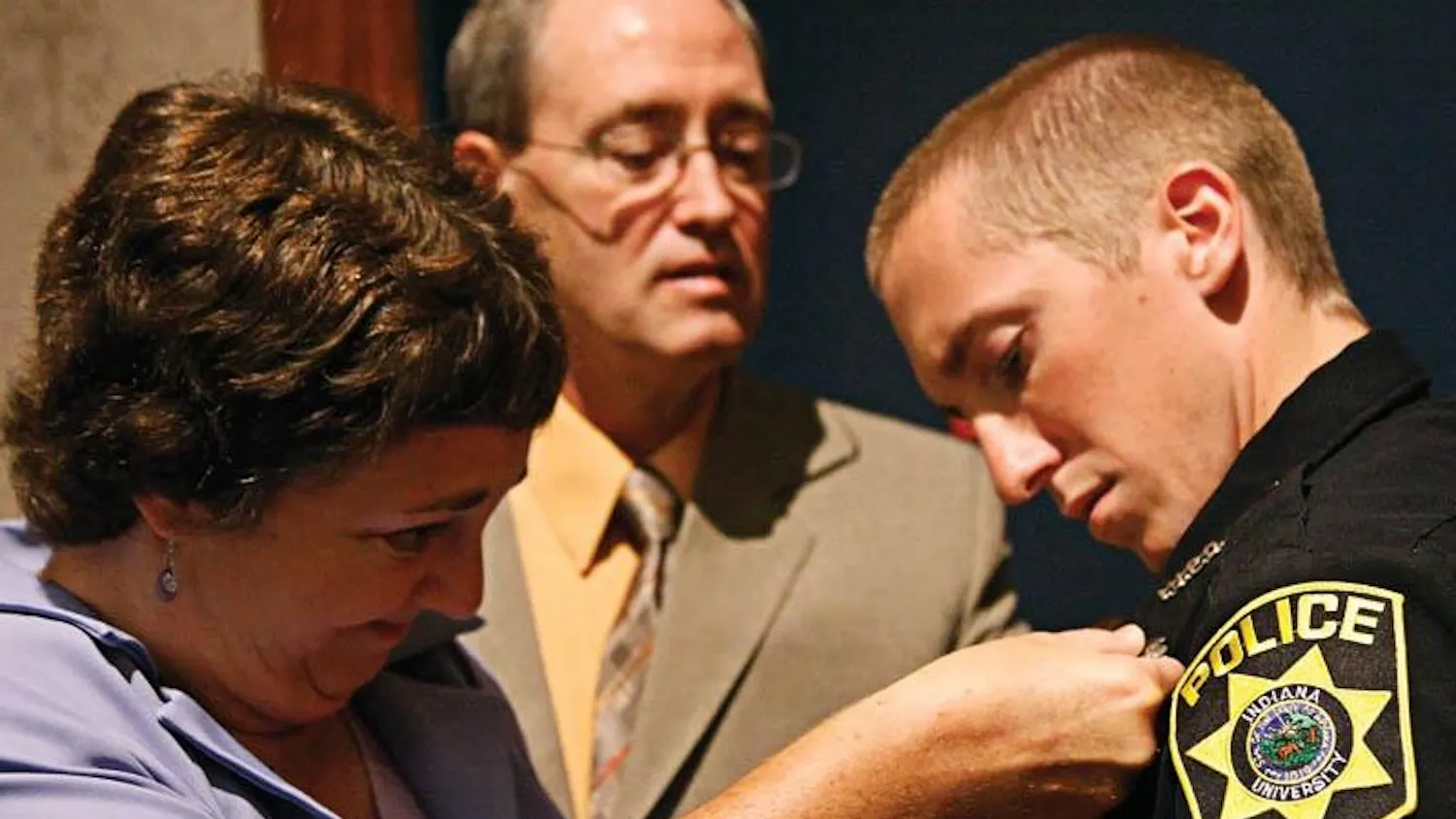 Diane and Nick Pratt, parents of recent IUPD graduate Phillip Pratt, pin Phillip's new badge to his uniform Saturday morning at Whittenburger Auditorium after the IUPD graduation ceremony. Phillip's older brother Jason was home from Indonesia for four months, and said he was excited to be able to come to the ceremony.