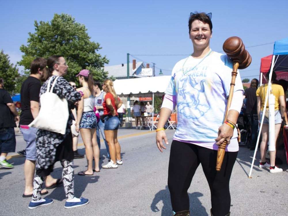 Brenda Rose, an auctioneer at Metzger Property Service, holds up a wooden hammer at the 2018 Bloomington Pridefest on East Kirkwood Avenue. 