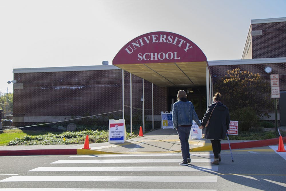 <p>A couple walks inside the polling site at University Elementary School on Election Day in Bloomington, Indiana.</p>