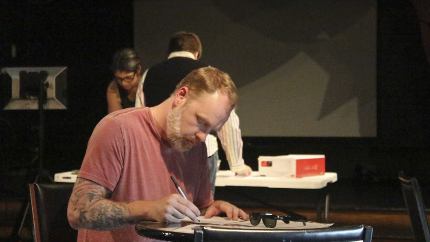Mat Alano-Martin writes letters Monday evening at The Back Door to those directly affected in Orlando’s attack. The staff at The Back Door will send the letters to the owners, staff and patrons of Pulse.