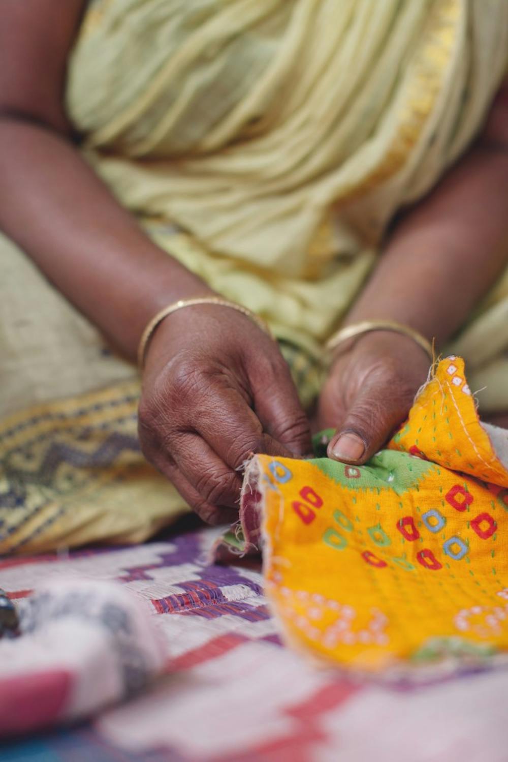 A woman from Sari Bari, an organization that helps women in India leave the sex trafficking by training them as artisans, repurposes an old sari, which is an Indian female garment. Photographs from photographers Frank and Sarah Schweikhardt, who visited Sari Bari in Calcutta, India, will be displayed at Gather until Jan. 31.