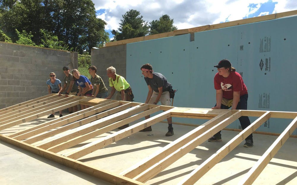IU Habitat for Humanity members raise the first wall on the basement of the house.  This is the first house IU Habitat has dedicated in 18 years.