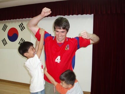 IU alum Bill Kapoun plays with Korean children. 
