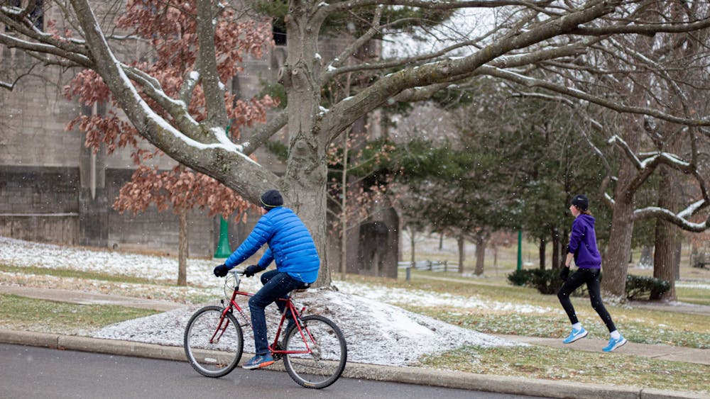 一个骑自行车的人和慢跑的人在第七街锻炼。据印第安纳大学的一份新闻稿称，第七街自行车道的建设预计将于8月9日完工，为印第安纳大学学生回国做准备。