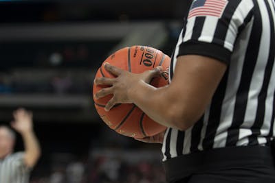 A referee holds a basketball March 6 at Bankers Life Fieldhouse in Indianapolis. IU men&#x27;s basketball team has paused workouts after multiple positive coronavirus cases.