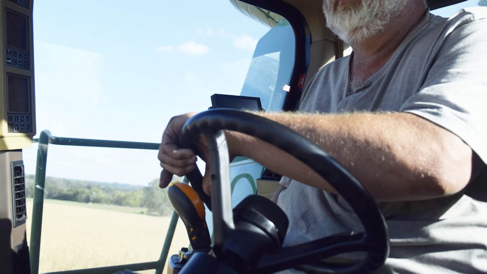 杰夫·迪克在印第安纳州埃利茨维尔附近的农场里开着拖拉机。迪克说他想知道他的父亲对现代农业技术的看法。